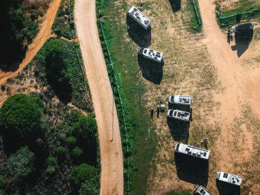 Çeşitli kervanlar, gün ortasında uzun gölgeler bırakarak güneş alan bir alana dağılmış ve bazı tanımlanamayan insanlarla kaynaşmışlar.