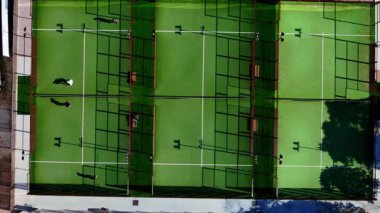 Oyuncular açık hava sahalarında yemyeşil alanlarla çevrili rekabetçi padel maçlarına çıkıyorlar.