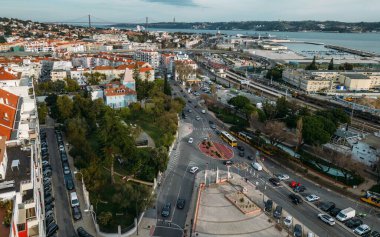 Lizbon 'daki Alges' in havadan insansız hava aracı görüntüsü marina ve hareketli sokaklar boyunca canlı şehir hayatı ve manzaralı deniz manzarası sergiliyor.