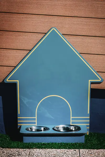 Evcil hayvan besleme istasyonu ahşap bir duvara karşı oturur. İki paslanmaz çelik kase içeriyor ve herhangi bir açık alana çekici bir dokunuş sağlıyor.