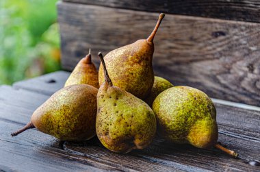 Kokulu, iştah açıcı armutlar sonbahar bahçesindeki ahşap bir masada..