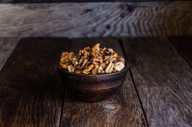 Peeled walnuts in an earthenware dish on a kitchen wooden table