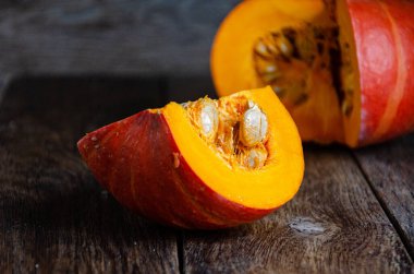 Cut pumpkin on a wooden table. Cooking in the kitchen.
