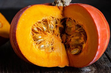 Cut pumpkin on a wooden table. Cooking in the kitchen.