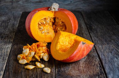Cut the pumpkin and its seeds on wooden boards.