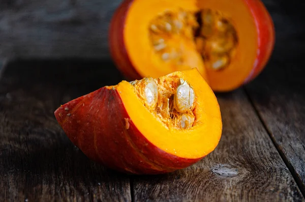 Cut pumpkin on a wooden table. Cooking in the kitchen.