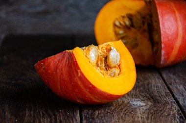 Cut pumpkin on a wooden table. Cooking in the kitchen.