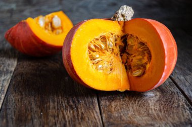 Cut pumpkin on a wooden table. Cooking in the kitchen.