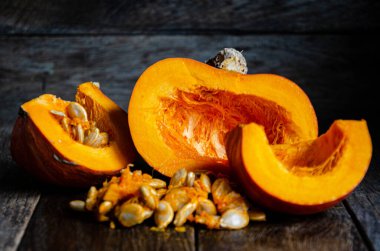 Sliced pumpkin in a white bowl on a wooden table.