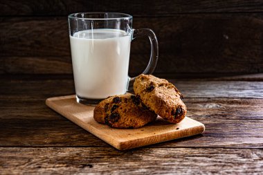 A glass of milk and oatmeal cookies on the kitchen table. Breakfast is light.