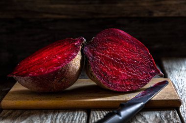 Kesme tahtasında pancar kökü ve koyu bir arka plan. Mutfakta ev yemeği..