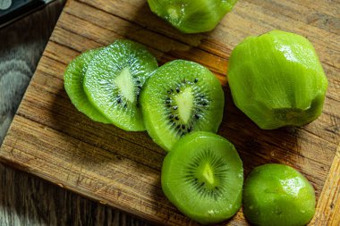 Kiwi mutfak tahtasındaki deriyi soydu ve kesti..