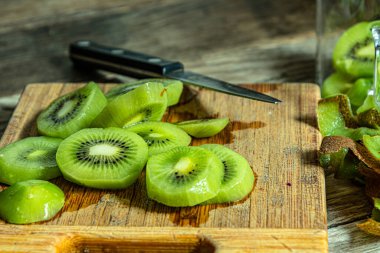 Kiwi mutfak tahtasındaki deriyi soydu ve kesti..