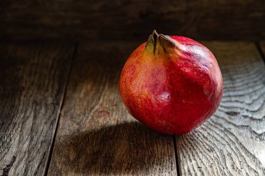 Tahta bir masada olgun kırmızı nar..