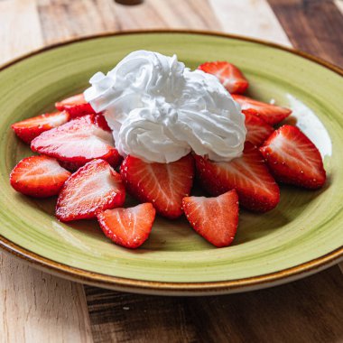 Kremalı bir tabakta çilek. Çok lezzetli..