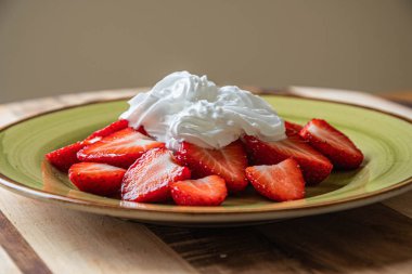 Kremalı bir tabakta çilek. Çok lezzetli..