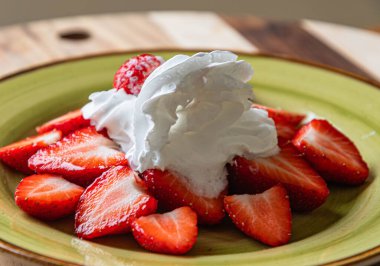 Kremalı bir tabakta çilek. Çok lezzetli..