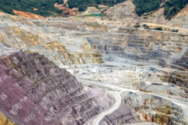 Blurred background of open pit mining. Aerial view of industrial slope on mineral mine site.