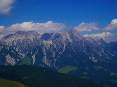 Bir yaz günü Saalbach Hinterglemm kayak merkezi yakınlarındaki dağlarda yeşil çayırlar, dağlar, bulutlar. Alpler, Avusturya. 