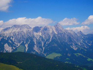 Bir yaz günü Saalbach Hinterglemm kayak merkezi yakınlarındaki dağlarda yeşil çayırlar, dağlar, bulutlar. Alpler, Avusturya. 