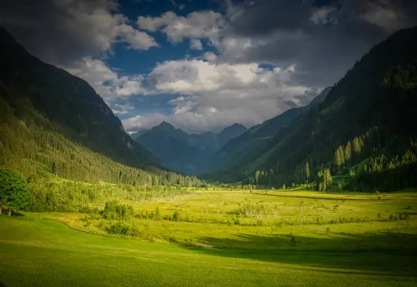 Güzel vadileri ve dağ tepeleri olan manzaralı dağ manzarası, yeşil çimenler, bulutlu gökyüzü. Yeşil, mavi. Schladminger Tauern, Alpler, Avusturya.