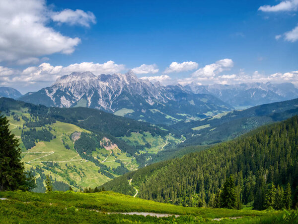 View on mountains near Saalbach Hinterglemm ski resort on a summer day,green meadows,mountains, clouds. Alps, Austria. 