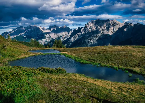 Osttirol bölgesindeki Lienzer Dolomiten Dağları 'na bir yaz öğleden sonra, dağlar, sivri kayalar, dağ gölü, gökyüzü, bulutlar. Alpler, Avusturya. 