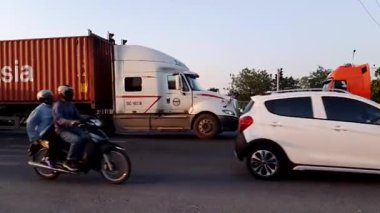 Trafiğe katılan motosikletli ve arabalı sokak sahneleri