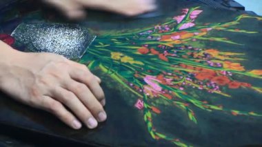Ressam dantelli bir tablo yapıyor.