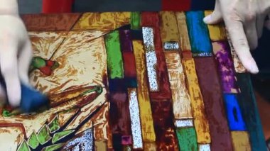 Ressam dantelli bir tablo yapıyor.