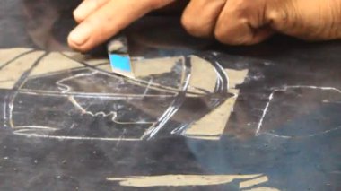 Ressam dantelli bir tablo yapıyor.