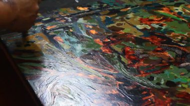 Ressam dantelli bir tablo yapıyor.