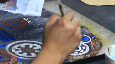 Ressam dantelli bir tablo yapıyor.