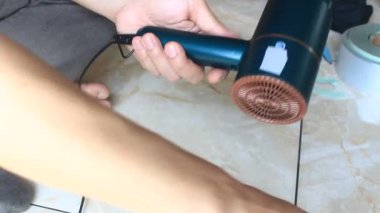  Adam saç kurutma makinesini tamir ediyor.