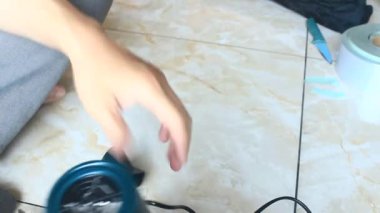  Adam saç kurutma makinesini tamir ediyor.