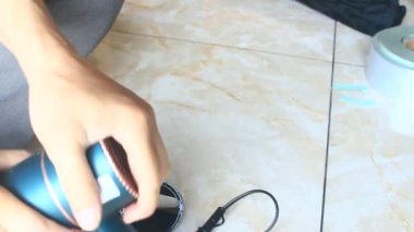  Adam saç kurutma makinesini tamir ediyor.