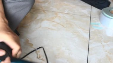  Adam saç kurutma makinesini tamir ediyor.