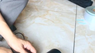  Adam saç kurutma makinesini tamir ediyor.