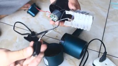  Adam saç kurutma makinesini tamir ediyor.