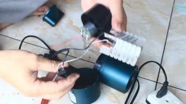  Adam saç kurutma makinesini tamir ediyor.