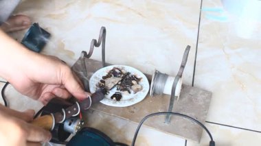  Adam saç kurutma makinesini tamir ediyor.