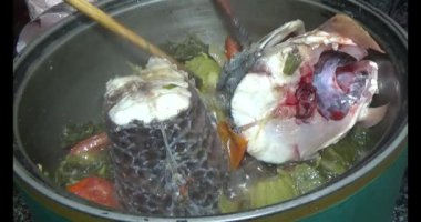 Balık çorbası pişir. Balığı temizle. Parçalara ayırmak için bıçak kullan. Yemek yaparken domates ve baharatlı kızartma ekleyin.