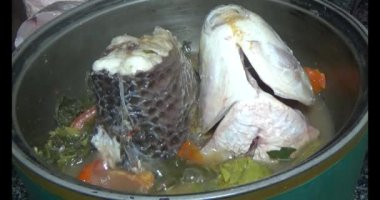 Balık çorbası pişir. Balığı temizle. Parçalara ayırmak için bıçak kullan. Yemek yaparken domates ve baharatlı kızartma ekleyin.