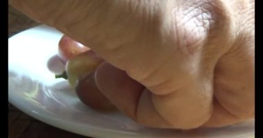 Tabakta üzüm var. Beyaz bir tabakta bir demet mor üzüm. Beyaz tabak dönüyor.