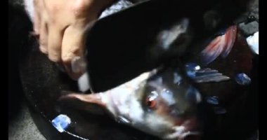 Balık çorbası pişir. Balığı temizle. Parçalara ayırmak için bıçak kullan. Yemek yaparken domates ve baharatlı kızartma ekleyin.