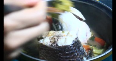 Balık çorbası pişir. Balığı temizle. Parçalara ayırmak için bıçak kullan. Yemek yaparken domates ve baharatlı kızartma ekleyin.