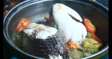 Balık çorbası pişir. Balığı temizle. Parçalara ayırmak için bıçak kullan. Yemek yaparken domates ve baharatlı kızartma ekleyin.