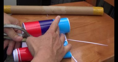 Adam araba gövdesine yapıştırmak için üç renkli çıkartma kullanıyor.