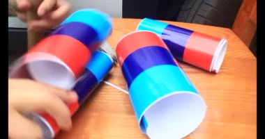 Adam araba gövdesine yapıştırmak için üç renkli çıkartma kullanıyor.