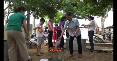 24 Kasım 2024, Haiduong, Vietnam. Genç bir adam, tanrılara ve ölen akrabalara adak kağıdı yakmak için çakmak kullanıyor. Bu bir Vietnam geleneği..